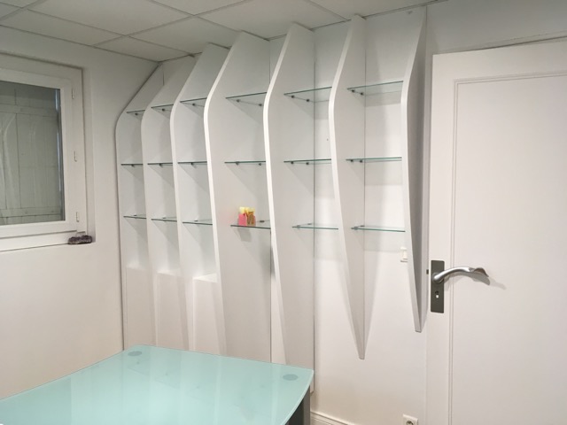 L’étagère design a trouvé sa place dans un cabinet médical de la région bordelaise. Montants et portes laqués blancs, étagères en verre.
